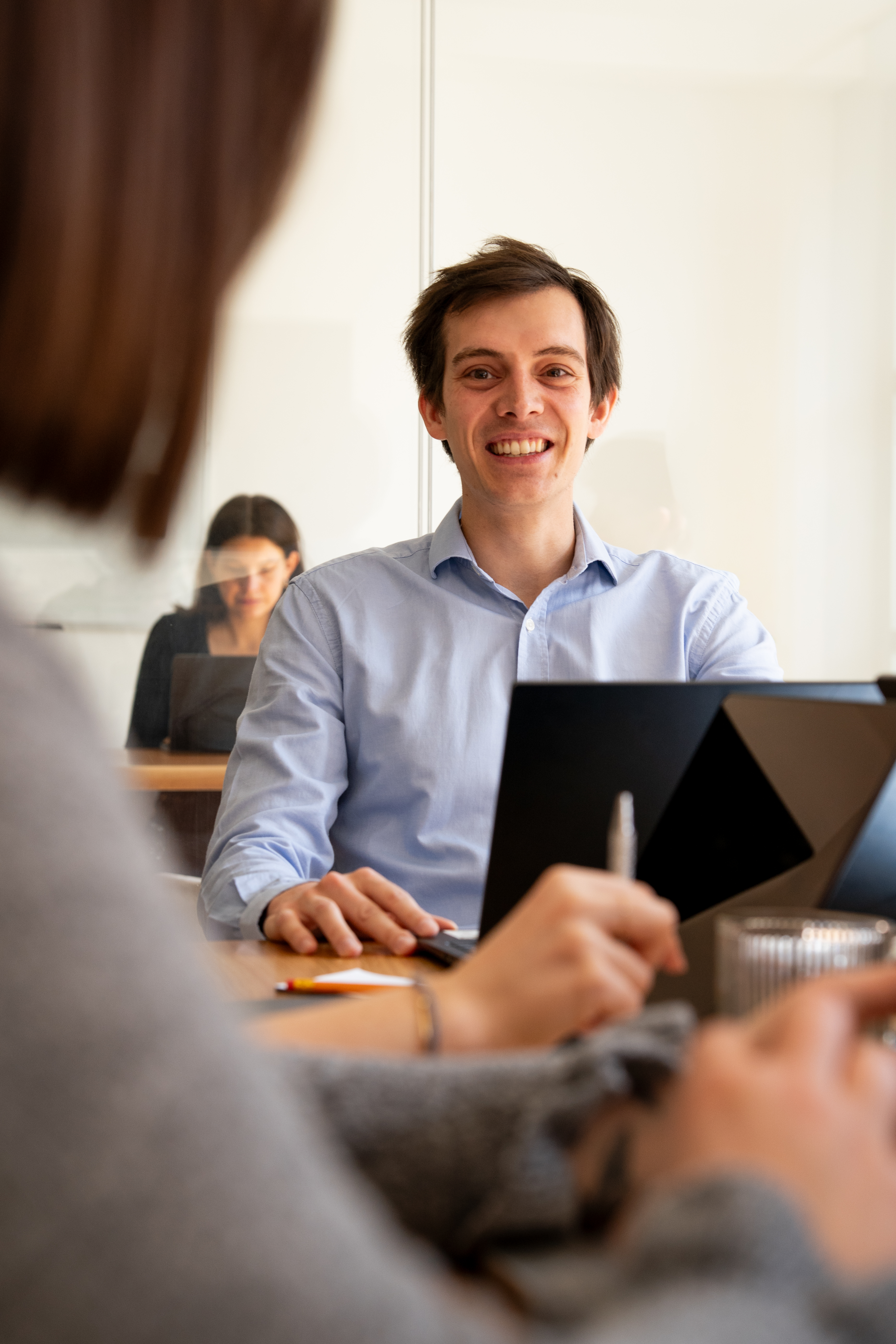 A Galadrim team in a workshop around a meeting table, with open laptops