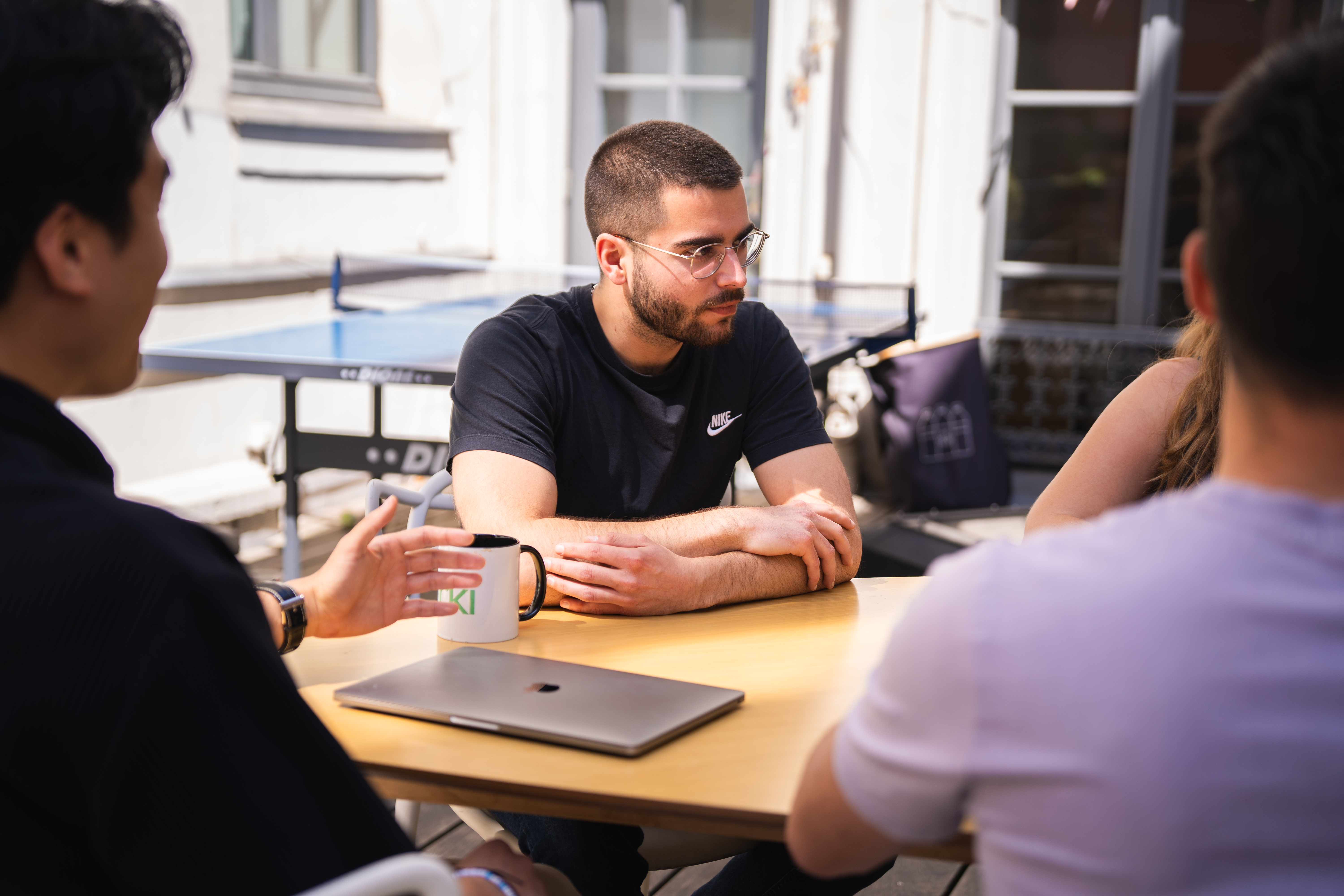 Three Galadrimers around a meeting table, a laptop placed in front of them